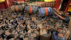 A worker arranges empty cooking gas cylinders at a depot in Kolkata. Since the LPG stove is about as costly as the connection, and the fuel several times costlier per year, almost two-thirds of all households given a connection will continue to use or soon revert to mostly using polluting wood.(REUTERS) A worker arranges empty cooking gas cylinders at a depot in Kolkata. Since the LPG stove is about as costly as the connection, and the fuel several times costlier per year, almost two-thirds of all households given a connection will continue to use or soon revert to mostly using polluting wood.(REUTERS)