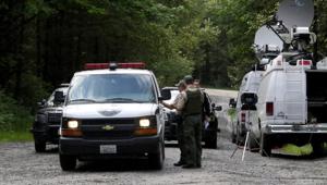 Washington State Fish and Wildlife Police confer with an individual from the King County Medical Examiner's office on a remote gravel road above Snoqualmie, Washington following a fatal cougar attack, Saturday, May 19, 2018.(AP) Washington State Fish and Wildlife Police confer with an individual from the King County Medical Examiner's office on a remote gravel road above Snoqualmie, Washington following a fatal cougar attack, Saturday, May 19, 2018.(AP)