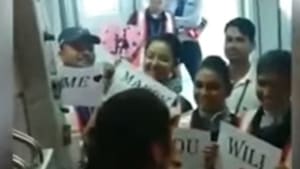 The airline staff, in an apparent show of support for the man, can be seen holding placards on the aerobridge with “will you marry me?” written on them.(Screen grab from the video)