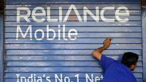 A man opens the shutter of a shop painted with an advertisement of Reliance Communications in Mumbai, India.(Reuters File Photo) A man opens the shutter of a shop painted with an advertisement of Reliance Communications in Mumbai, India.(Reuters File Photo)