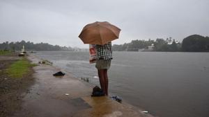A man dresses up holding an umbrella as it started raining after he bathed in the River Periyar in Kochi, Kerala, on May 29, 2018.(AP) A man dresses up holding an umbrella as it started raining after he bathed in the River Periyar in Kochi, Kerala, on May 29, 2018.(AP)