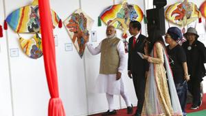 Indian Prime Minister Narendra Modi, left, talks with Indonesian President Joko Widodo, centre, at the National Monument Monas during India-Indonesia kite exhibition in Jakarta, Indonesia.(AP)