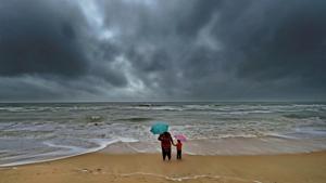 A woman standing with her son at Marina beach following heavy downpour due to the onset of Northeast monsoon in Chennai.(PTI Representative Photo) A woman standing with her son at Marina beach following heavy downpour due to the onset of Northeast monsoon in Chennai.(PTI Representative Photo)