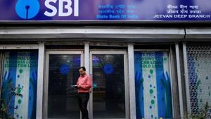 A man checks his mobile phones in front of State Bank of India (SBI) branch in Kolkata, February 9, 2018. The raise of lending rate makes loans costlier for consumers.(Reuters File) A man checks his mobile phones in front of State Bank of India (SBI) branch in Kolkata, February 9, 2018. The raise of lending rate makes loans costlier for consumers.(Reuters File)
