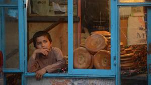 In this photograph taken on June 1, 2018, a young Afghan boy sits at a bakery as he waits to sell bread in Mazar-i-Sharif.(AFP)