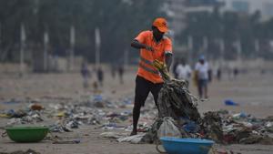 A municipal authority worker cleans up plastic waste on Juhu beach in Mumbai during World Environment Day on June 5.(AFP Photo)