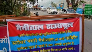A banner tied to a barricade reads' the popular hill station of Nainital has shut its parking for tourists arriving in their vehicles as it is houseful', in Nainital on Tuesday. The move comes after the Uttarakhand High Court reprimanded authorities for poor traffic management in the town.(PTI) A banner tied to a barricade reads' the popular hill station of Nainital has shut its parking for tourists arriving in their vehicles as it is houseful', in Nainital on Tuesday. The move comes after the Uttarakhand High Court reprimanded authorities for poor traffic management in the town.(PTI)