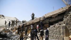 Policemen and people search for victims at the site of a Saudi-led airstrike on the police headquarters in Sanaa, Yemen. File Photo(AP)