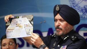 Malaysia's commercial crime investigations chief Amar Singh shows a picture of jewellry seized from properties linked to former prime minister Najib Razak in Kuala Lumpur on Wednesday.(Vincent Thian/AP) Malaysia's commercial crime investigations chief Amar Singh shows a picture of jewellry seized from properties linked to former prime minister Najib Razak in Kuala Lumpur on Wednesday.(Vincent Thian/AP)