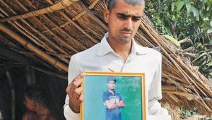 Ashkant Vikram Singh, younger brother of Santosh Kumar Singh, shows his brother’s portrait.(HT Photo)