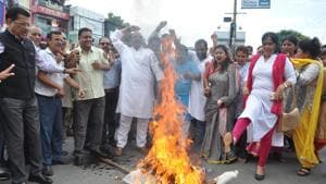 Congress workers burn an effigy of the Uttarakhand government in Dehradun on Saturday to protest suspension of a woman schoolteacher.(HT PHOTO)