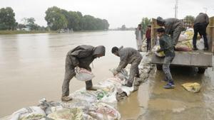 Labourers place sandbags along the Jhelum river bank in an attempt to prevent flood water from spilling into residential areas in Srinagar on Saturday.(Waseem Andrabi / HT Photo) Labourers place sandbags along the Jhelum river bank in an attempt to prevent flood water from spilling into residential areas in Srinagar on Saturday.(Waseem Andrabi / HT Photo)