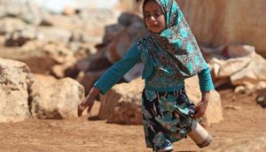 Eight year-old Maya Mohammad Ali Merhi walks using prosthetic legs made by her father from tin cans in a camp for displaced people, in the northern Syrian province of Idlib on June 20, 2018.(AFP Photo) Eight year-old Maya Mohammad Ali Merhi walks using prosthetic legs made by her father from tin cans in a camp for displaced people, in the northern Syrian province of Idlib on June 20, 2018.(AFP Photo)