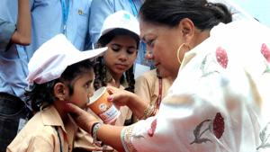 CM Vasundhara Raje offers milk to a schoolgirl at a government school in Dehmi Kalan in Jaipur on Monday.(HT Photo) CM Vasundhara Raje offers milk to a schoolgirl at a government school in Dehmi Kalan in Jaipur on Monday.(HT Photo)