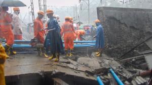 Rescue workers clear the debris after a foot overbridge collapsed on the Western Railway tracks, at Andheri station, following heavy rain, in Mumbai on Tuesday.(PTI photo)