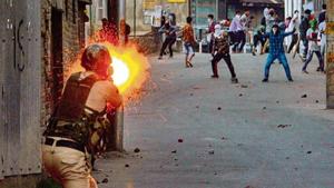 A policeman fires a tear gas shell towards the protesters hurling stones at forces in Srinagar on Saturday. PTI(PTI) A policeman fires a tear gas shell towards the protesters hurling stones at forces in Srinagar on Saturday. PTI(PTI)