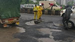 Traffic officials temporarily filled up potholes with concrete pieces left on the side of the highway during repairs done last year.(HT Photo) Traffic officials temporarily filled up potholes with concrete pieces left on the side of the highway during repairs done last year.(HT Photo)