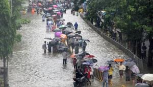 People walk along a flooded street during heavy rain showers, at Parel, in Mumbai, on Tuesday, July 10, 2018.(Bhushan Koyande/HT) People walk along a flooded street during heavy rain showers, at Parel, in Mumbai, on Tuesday, July 10, 2018.(Bhushan Koyande/HT)