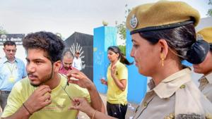 A police personnel removes a thread from the collar of a candidate before entering the examination centre for the Rajasthan police constable recruitment exam 2018 in Bikaner on Sunday.(PTI) A police personnel removes a thread from the collar of a candidate before entering the examination centre for the Rajasthan police constable recruitment exam 2018 in Bikaner on Sunday.(PTI)