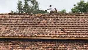 A student fixes the damaged roof of the school building.(HT Photo) A student fixes the damaged roof of the school building.(HT Photo)