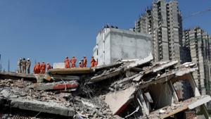 Rescue workers look for survivors amid rubble at the site of a collapsed residential building at Shah Beri village in Greater Noida, on Wednesday.(Reuters) Rescue workers look for survivors amid rubble at the site of a collapsed residential building at Shah Beri village in Greater Noida, on Wednesday.(Reuters)