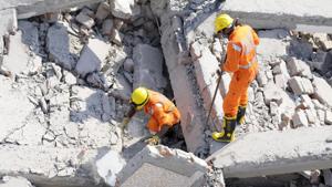 National Disaster Response Force (NDRF) rescue workers retrieve a dead body from the debris of the buildings, at Shahberi village in Greater Noida.(Sunil Ghosh/HT Photo) National Disaster Response Force (NDRF) rescue workers retrieve a dead body from the debris of the buildings, at Shahberi village in Greater Noida.(Sunil Ghosh/HT Photo)