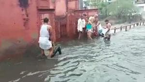 Locals rescue a bike rider from falling into the overflowing drain at Kartarpura in Jaipur on Tuesday.(Video grab) Locals rescue a bike rider from falling into the overflowing drain at Kartarpura in Jaipur on Tuesday.(Video grab)