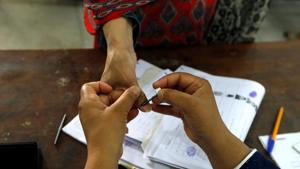 A woman receives an ink mark on her thumb before casting her ballot during general election, at a polling station in Rawalpindi, Pakistan July 25, 2018.(REUTERS)
