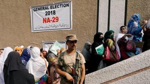 Army soldier stands guards where electoral workers gather to collect election materials at distribution point, ahead of general election in Peshawar, Pakistan.(Reuters Photo) Army soldier stands guards where electoral workers gather to collect election materials at distribution point, ahead of general election in Peshawar, Pakistan.(Reuters Photo)