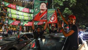 Supporters of Imran Khan, head of the Pakistan Tehreek-e-Insaf (PTI), also known as Movement for Justice, hold signs while celebrating on a street in Lahore, Pakistan, on Wednesday, July 25, 2018. Pakistan's Imran Khan took an early lead in a tightly-fought election.(Bloomberg) Supporters of Imran Khan, head of the Pakistan Tehreek-e-Insaf (PTI), also known as Movement for Justice, hold signs while celebrating on a street in Lahore, Pakistan, on Wednesday, July 25, 2018. Pakistan's Imran Khan took an early lead in a tightly-fought election.(Bloomberg)