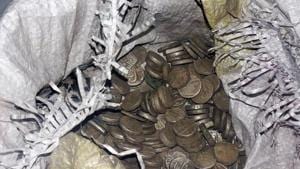 The pot, containing 329 coins weighing nearly four kilos, was found when the ground was being dug to construct the main gate of the Bhairav Temple in the village located in Khirsu block.(HT PHOTO) The pot, containing 329 coins weighing nearly four kilos, was found when the ground was being dug to construct the main gate of the Bhairav Temple in the village located in Khirsu block.(HT PHOTO)