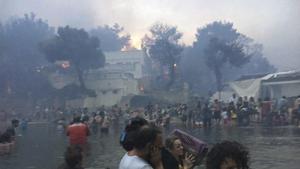 Mati : In this Monday, July 23, 2018 image from video provided by Elia Kallia, people escaping wildfires wade into the waters of the Mati : In this Monday, July 23, 2018 image from video provided by Elia Kallia, people escaping wildfires wade into the waters of the