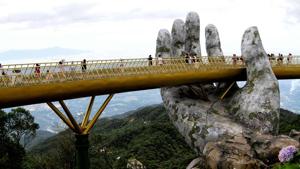 Visitors walk along the 150-metre-long Cau Vang "Golden Bridge" in the Ba Na Hills near Danang.(AFP) Visitors walk along the 150-metre-long Cau Vang "Golden Bridge" in the Ba Na Hills near Danang.(AFP)