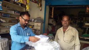 Member of anti-polythene squad issues challan to a shopkeeper for keeping polythene bags in Dehradun.(HT Photo) Member of anti-polythene squad issues challan to a shopkeeper for keeping polythene bags in Dehradun.(HT Photo)