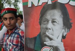 A supporters of Pakistan's cricketer-turned politician and head of the Pakistan Tehreek-e-Insaf party Imran Khan stands next to poster of him near Khan’s residence in Islamabad. The use of the phone app and the database partly explains how Khan’s party managed to win tight-margin races in the nuclear-armed nation of 208 million people.(AFP) A supporters of Pakistan's cricketer-turned politician and head of the Pakistan Tehreek-e-Insaf party Imran Khan stands next to poster of him near Khan’s residence in Islamabad. The use of the phone app and the database partly explains how Khan’s party managed to win tight-margin races in the nuclear-armed nation of 208 million people.(AFP)