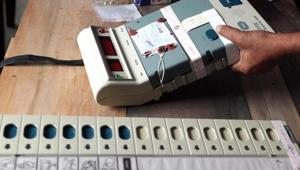 Election Commission officials seal an Electronic Voting Machine (EVM) prior to the start of voting at a polling station.(AFP File Photo)
