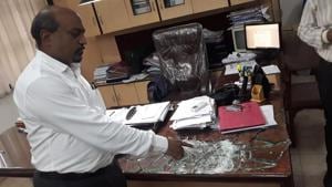 Anwar Shaikh, principal of Anjuman- E -Khairul Islam’s Poona college of arts, commerce and science, shows the glass that the criminal broke while threatening him.(HT PHOTO) Anwar Shaikh, principal of Anjuman- E -Khairul Islam’s Poona college of arts, commerce and science, shows the glass that the criminal broke while threatening him.(HT PHOTO)