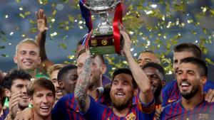 Barcelona's Lionel Messi (C) lifts the trophy as he celebrates winning the Spanish Super Cup with teammates.(REUTERS)