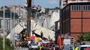 Firefighters and rescue workers stand at the site of a collapsed Morandi Bridge in the port city of Genoa, Italy.(Reuters Photo) Firefighters and rescue workers stand at the site of a collapsed Morandi Bridge in the port city of Genoa, Italy.(Reuters Photo)