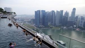 Tourists look out into the skyline of the city from an infinity pool atop the 57-storey Marina Bay Sands hotel in Singapore.(REUTERS) Tourists look out into the skyline of the city from an infinity pool atop the 57-storey Marina Bay Sands hotel in Singapore.(REUTERS)