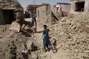 Afghan residents walk near destroyed houses after a Taliban attack in Ghazni on August 16, 2018.(AFP) Afghan residents walk near destroyed houses after a Taliban attack in Ghazni on August 16, 2018.(AFP)