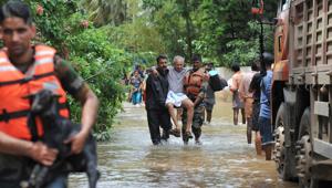 Rescue personnel carry animals and elderly people to safety during a rescue operation in Thrissur’s Mala village on Sunday.(AFP Photo) Rescue personnel carry animals and elderly people to safety during a rescue operation in Thrissur’s Mala village on Sunday.(AFP Photo)