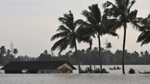 Two men row a boat through a flooded paddy field next to an inundated structure in Alappuzha, Kerala.(AP Photo) Two men row a boat through a flooded paddy field next to an inundated structure in Alappuzha, Kerala.(AP Photo)