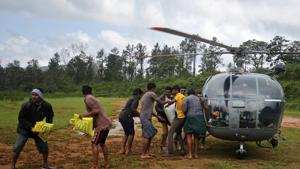 Flood victims unload food and relief material from an Indian Air force helicopter at Nelliyampathy Village, in Kerala, on Tuesday.(REUTERS) Flood victims unload food and relief material from an Indian Air force helicopter at Nelliyampathy Village, in Kerala, on Tuesday.(REUTERS)