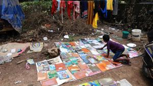 A student dries out his school books after flooding hit his home in Kochi on August 21.(AFP Photo) A student dries out his school books after flooding hit his home in Kochi on August 21.(AFP Photo)