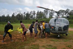 Flood victims unload food and relief material from an Indian Air force helicopter at Nelliyampathy Village, Kerala, August 21, 2018.(REUTERS) Flood victims unload food and relief material from an Indian Air force helicopter at Nelliyampathy Village, Kerala, August 21, 2018.(REUTERS)
