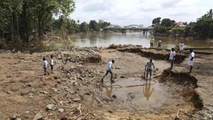 People assess damage caused by floods on the outskirts of Kochi in Kerala on Wednesday.(AP) People assess damage caused by floods on the outskirts of Kochi in Kerala on Wednesday.(AP)