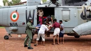 People help a woman disembark from an Indian Navy helicopter at a relief camp after being rescued from a flooded area in Kerala on August 17.(REUTERS) People help a woman disembark from an Indian Navy helicopter at a relief camp after being rescued from a flooded area in Kerala on August 17.(REUTERS)