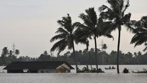 Two men row a boat through a flooded paddy field next to an inundated structure in Alappuzha, Kerala.(AP Photo) Two men row a boat through a flooded paddy field next to an inundated structure in Alappuzha, Kerala.(AP Photo)