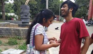 A girl ties rakhi to a college friend. A girl ties rakhi to a college friend.